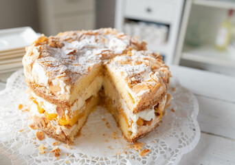 Delicious summer cake or torte with whipped cream filling, peaches and meringue topping