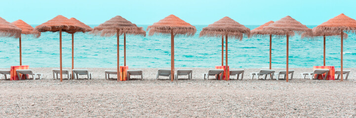 Sombrillas y tumbonas preparadas en una playa del mar Mediterráneo