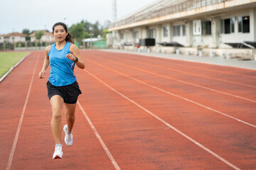 Fototapeta premium Asia mature woman runner training on racetrack and field 