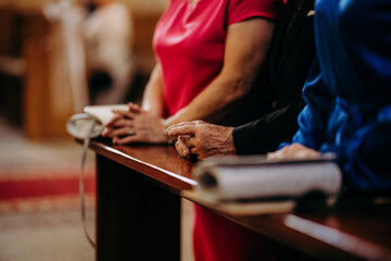 dłonie ludzi modlących się w kościele