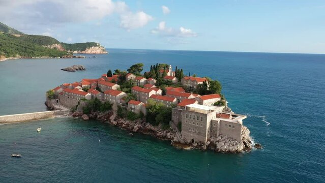 Amazing Aerial around view of Sveti Stefan resort island in Montenegro, 4k, drone video. The small old town of Sveti Stefan and resort in Montenegro