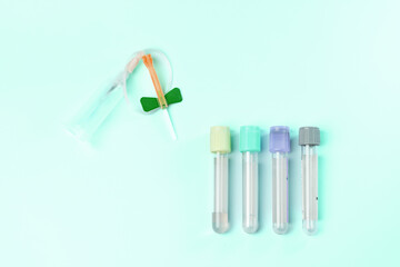 A collection of medical tubes with a green band tied to one of them. The tubes are of different...