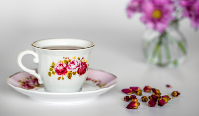 Tea rose flowers and cup of tea