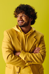 Handsome young man in yellow suit with arms crossed.