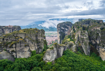 Aerial view of the misty cliffs of Meteora Valley and the small picturesque towns of Kastraki and Kalampaka at their foot, Greece.