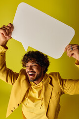 Handsome Indian man in vibrant outfit with speech bubble above his head.