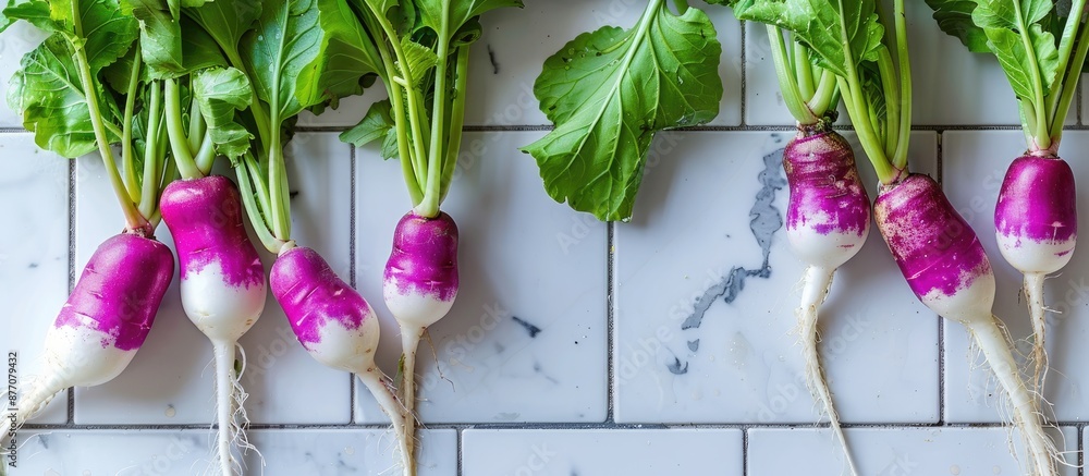 Aufkleber close-up shot of vibrant purple and green daikon radishes placed on a white tiled table, with a clea