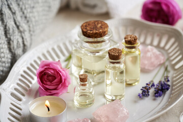 Bottles of aromatherapy essential oil with lavender and rose de Mai flowers and rose quartz stones