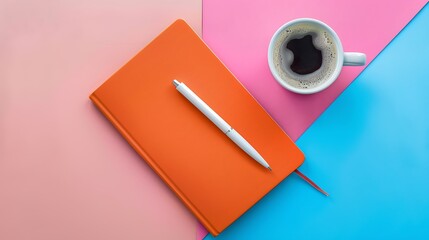 Orange note book white pen and cup of coffee isolated on pink and blue background