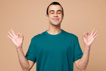 Young spiritual middle eastern man wear blue t-shirt casual clothes hold spreading hands in yoga om...