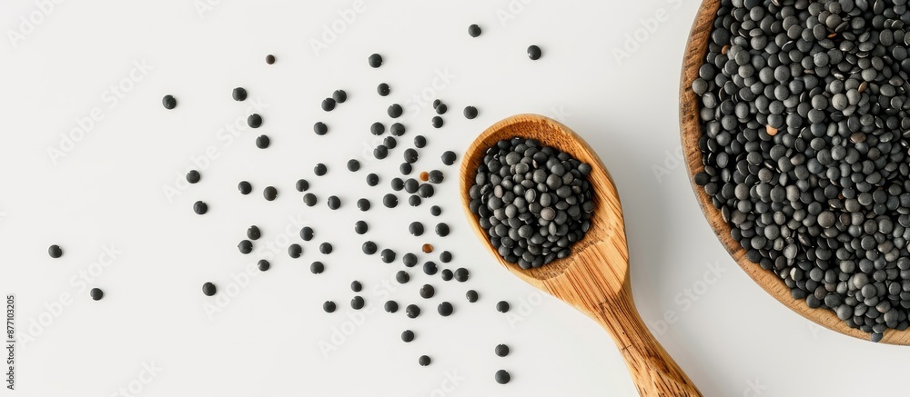 Poster black lentils beans with a wooden spoon against a white backdrop with room for text or other element