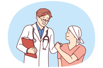 Doctor shakes hands with little cancer patient undergoing chemotherapy to fight cancer. Teenage boy with cancer lost his hair due to radiation exposure and needs support of clinic staff and parents