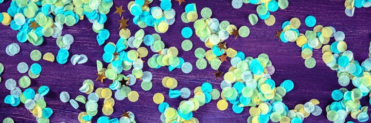 Festive panorama with confetti. Carnival greeting card with golden stars on a purple background