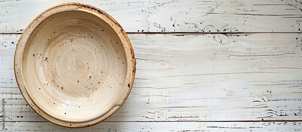 Aufkleber Top-down view of an empty ceramic bowl on a white wooden table, with room for adding text or a copy space image included.