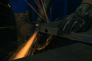 Detail of heavy industry manufacturing, sparks come out of a metal working welder.