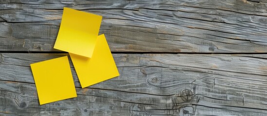 Wooden surface with two yellow sticky notes offering copy space for your office message.