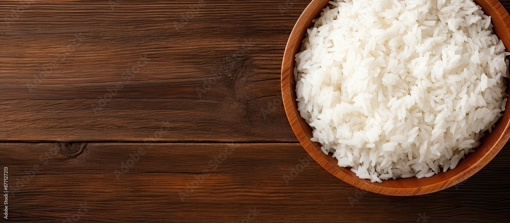 Poster top view image of a bowl of cooked rice on a wooden background with ample copy space for text or gra