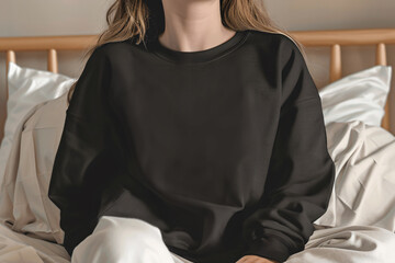 Woman sitting in a black oversize sweatshirt. Blank black sweatshirt mockup.