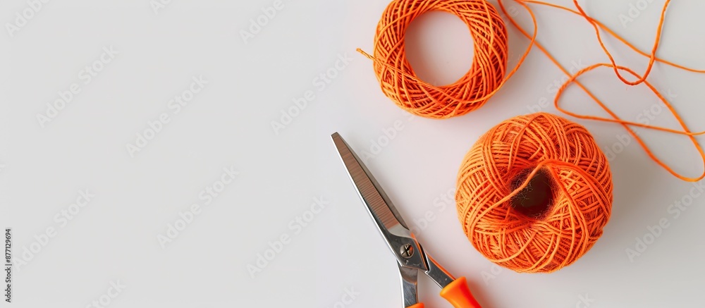 Poster A color string pattern on a white backdrop features an orange thread with a knot, scissors nearby, presented as a composition with copy space image.