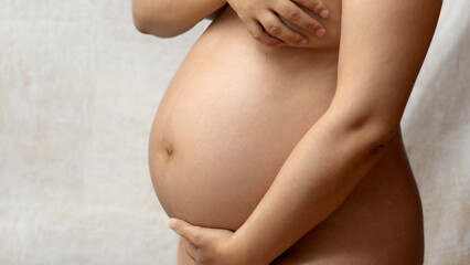6 month pregnant belly naked on background
