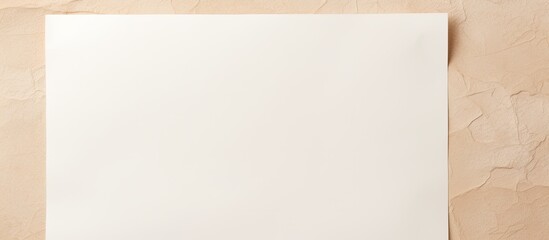 Fototapeta premium Overhead view of a blank white paper on a beige background with copy space image.