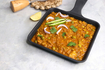 Indian famous dish Mutton matar Kheema Pav or Khima Paav is a minced goat meat curry. Mutton keema cooked with onion, tomatoes, potatoes, green peas along with Indian spices. copy sapce.