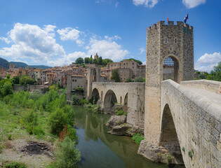 Obraz premium Girona, Spain - 7 July, 2024: The medieval Pont Vell bridge crossing the River Fluvia at Besalu, Catalonia