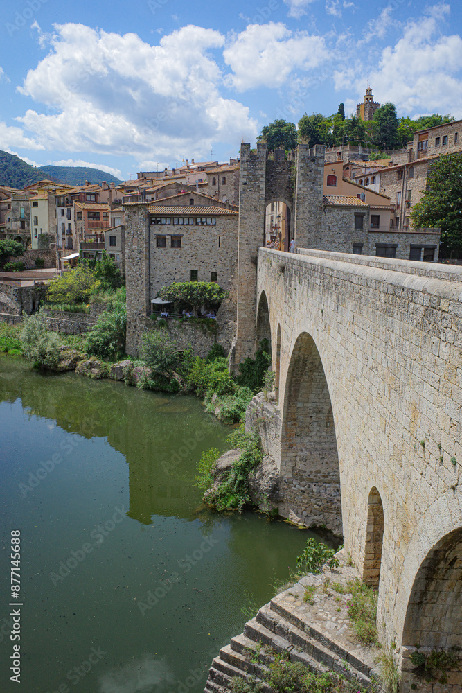 Wall mural girona, spain - 7 july, 2024: the medieval pont vell bridge crossing the river fluvia at besalu, cat