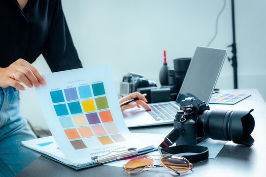 Female photographer meeting to select photos and check colors in studio