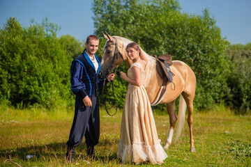 A man and a young woman in 19th century clothing. A man leads a horse by the reins. Scene from the novel