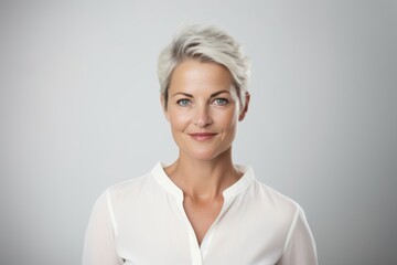 Fototapeta premium Closeup portrait of a beautiful business woman smiling at the camera over grey background