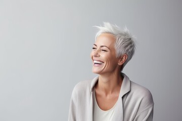 Cheerful young woman with short white hair smiling and looking away