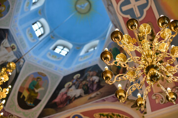 fragment of a painted ceiling in a modern Orthodox church and a chandelier