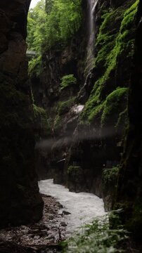 Brown textured stone walls in a dark rocky gorge tunnel in Partnachklamm