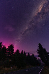 Milky way and Aurora australis over the forest on the road in rural scene at New Zealand