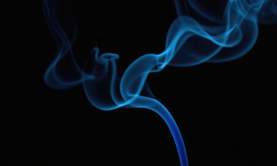 A beautiful stream of ethereal blue smoke rises gracefully against a dark background, creating a contrasting visual that evokes a sense of mystery and tranquil elegance.