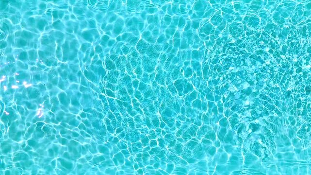 Blue water in the swimming pool with light reflections. Slow motion