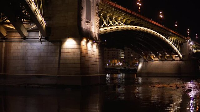 Margit Bridg bridge connecting Pest and Buda across the Danube river, City by night. Night view of the old town. The bridge and buildings of the old town seen from the river. Budapest, Hungary
