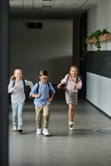 Fototapeta premium A group of young children laughing and running through a hallway, filled with excitement and energy.