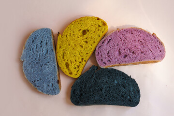 Fresh homebaked artisan colorful  sourdough bread. Slices of bread isolated on pastel pink  background, design element.