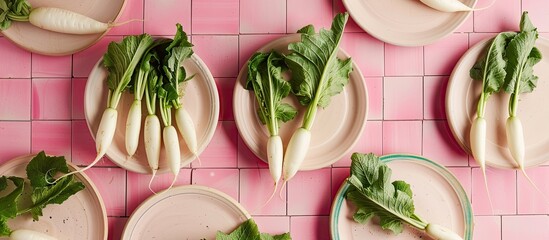 Fresh daikon radishes on plates against a pink tile background ideal for a copy space image