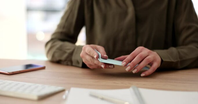 Female manager puts money into blue envelope after counting dollar banknotes. Woman sits at table checking payment for successful sales slow motion