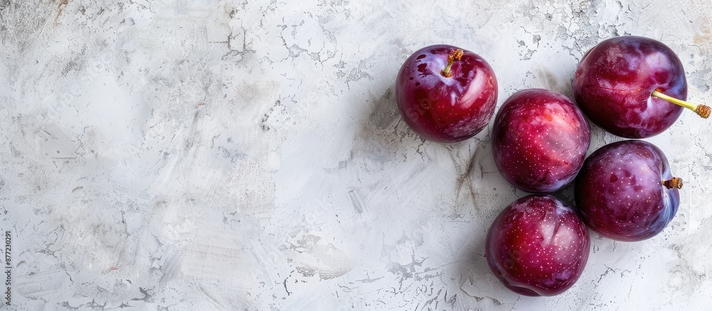 Aufkleber ripe plums washed on a white rustic backdrop with ample copy space image