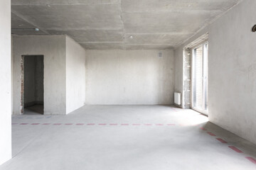 Obraz premium interior of the apartment without decoration in gray colors. rough finish