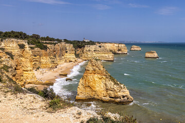 Obraz premium Praia da Marinha Beach among rock islets and cliffs seen from Seven Hanging Valleys Trail, Algarve, Portugal