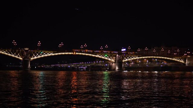 Margit Bridg bridge connecting Pest and Buda across the Danube river, City by night. Night view of the old town. The bridge and buildings of the old town seen from the river. Budapest, Hungary