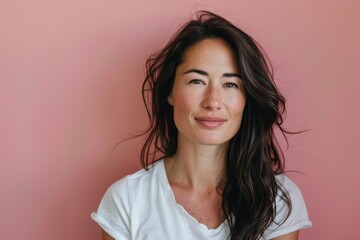 Fototapeta premium Portrait of a content woman in her 30s dressed in a casual t-shirt on solid color backdrop