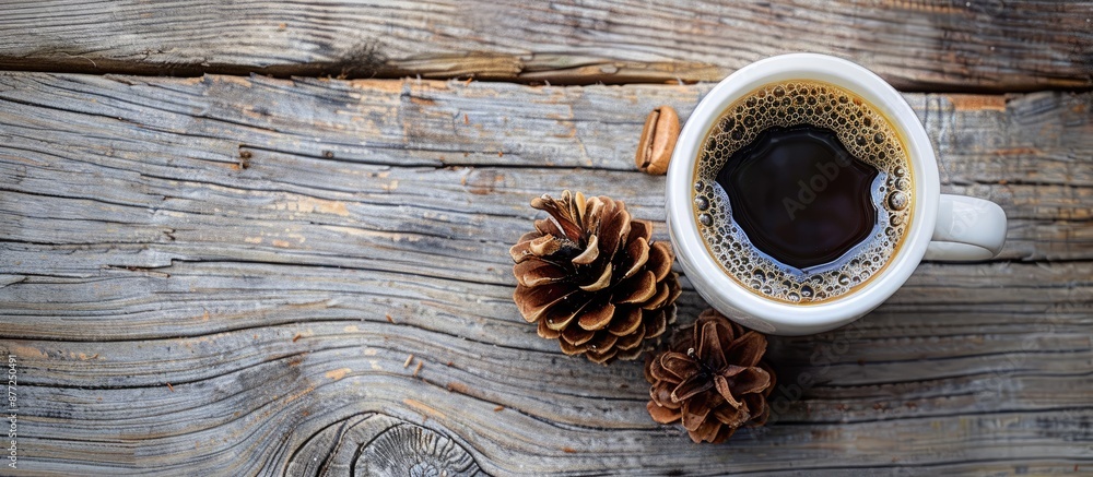 Poster a rustic themed top down view of coffee with a pine cone on a wooden table featuring ample copy spac
