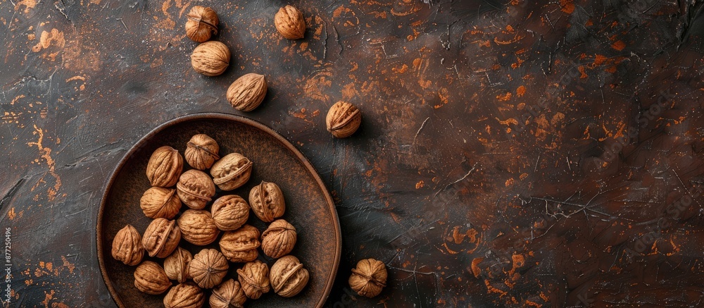 Leinwandbilder Top view of inshell walnuts arranged on a clay plate against a textured backdrop providing copy space image