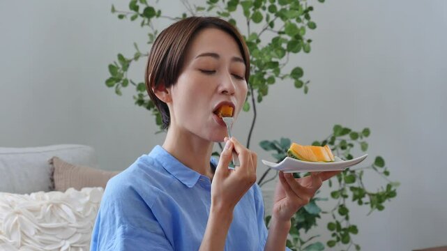 自宅でメロンを食べる女性